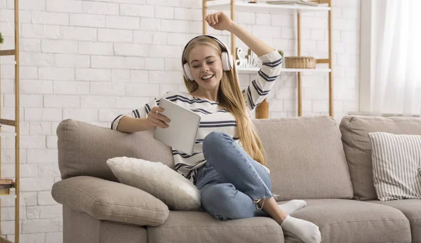 Emotional girl with wireless headset holding digital tablet — Stok fotoğraf