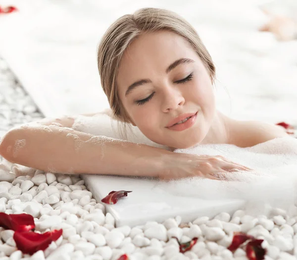 눈을 감고 목욕을 즐기고 있는 즐거운 젊은 여자의 모습 — 스톡 사진