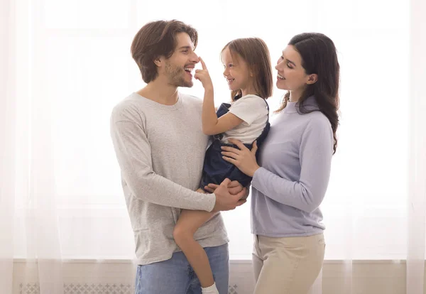 Pais felizes se divertindo com sua filhinha bonito em casa — Fotografia de Stock