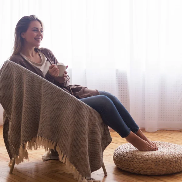 Fröhliche Frau ruht sich zu Hause mit Kaffee aus — Stockfoto