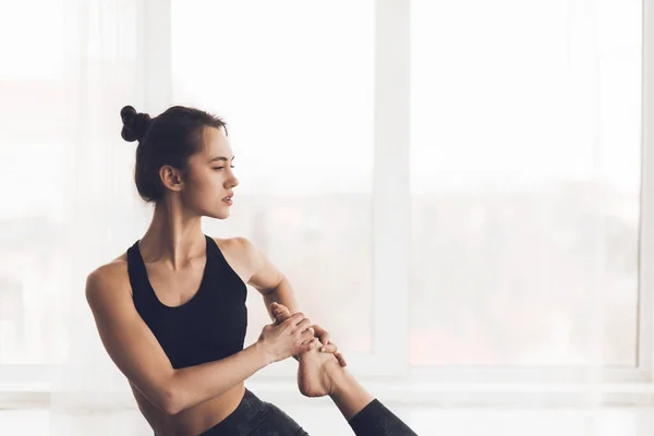 Giovane donna sportiva che si estende su tappetino yoga — Foto Stock