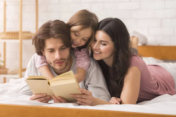 Kochający rodzice czytający bajki swojej córce — Zdjęcie stockowe