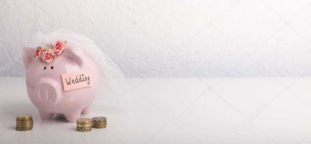 Piggy bank with wedding veil on gray background