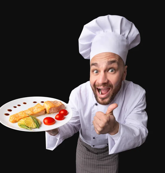 Chef Emocionado Mostrando Placa Con Salmón Filete Gestos Pulgares-Up, Estudio — Foto de Stock