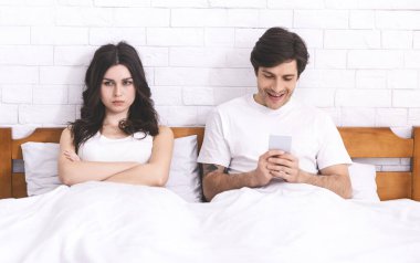 Üzgün eş cep telefonlu kocasıyla oynarken görmezden geldi.