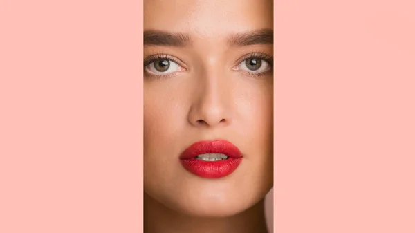 Menina com lábios vermelhos gordos olhando através de moldura de papel rosa — Fotografia de Stock