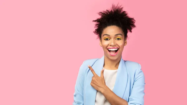 Mujer afro sonriente señalando con el dedo el espacio libre —  Fotos de Stock