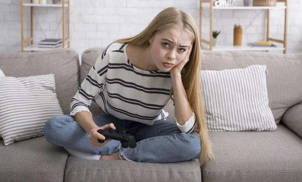 Ragazza annoiata giocare ai videogiochi da solo a casa — Foto Stock