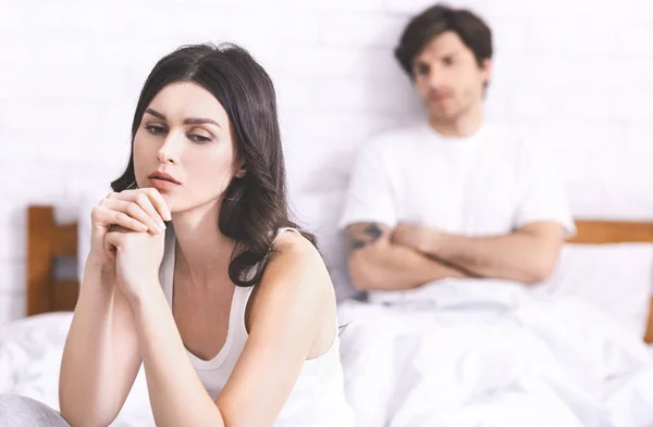 Offended woman sitting aside of her husband after quarrel — Stock Photo, Image