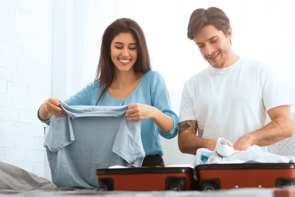 Reisekonzept. Paar packt Kleidung in Valise — Stockfoto