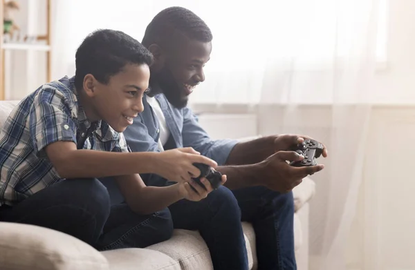 Afro padre e hijo jugando videojuegos con joysticks — Foto de Stock