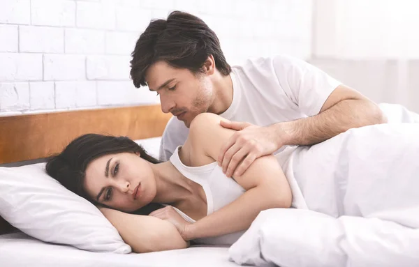 죄를 지은 남자가 침대에서 감정 이상 한 아내와 접촉하려고 애쓰는 모습 — 스톡 사진