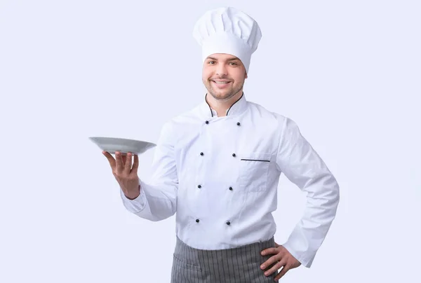 Chef hombre posando con la placa sonriendo a la cámara, Studio Shot — Foto de Stock