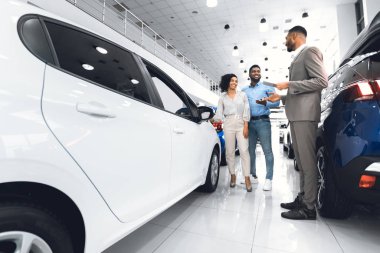 Spouses Choosing Auto With Seller In Luxury Dealership Center