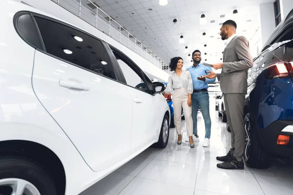 Los cónyuges eligen auto con vendedor en el centro de concesionarios de lujo — Foto de Stock