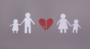 Man and woman holding children over gray background