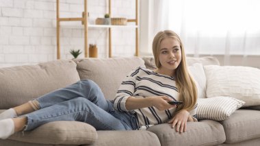 Breezy girl laying on couch at home, watching TV