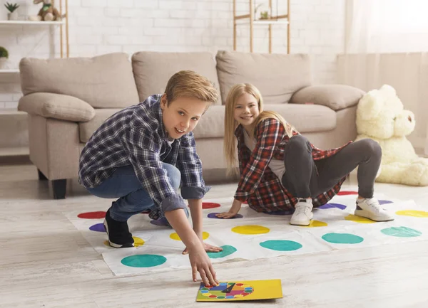 Bratr a sestra se baví hraní Twister hry na podlaze — Stock fotografie