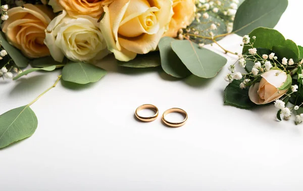 Anelli dorati con rose su sfondo bianco, panorama — Foto Stock