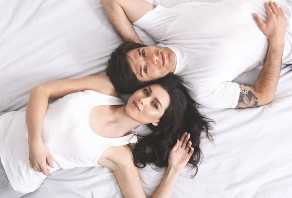 Retrato de estilo de vida de pareja joven acostada en la cama —  Fotos de Stock