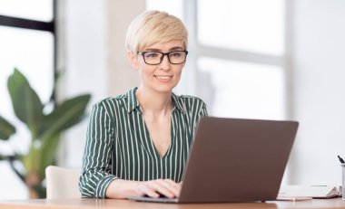 Lady Working On Laptop Typing Business Report Sitting In Office