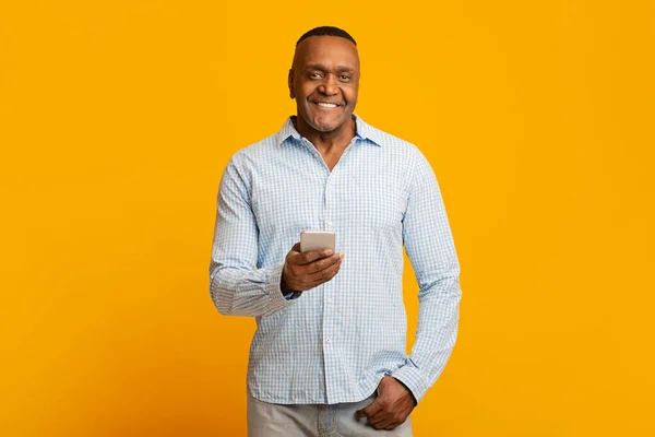 Mature african american man networking on cellphone — Stockfoto