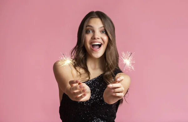 Excited Girl Holding Sparklers, Enjoying Party, Posing Over Pink Background — Stok fotoğraf