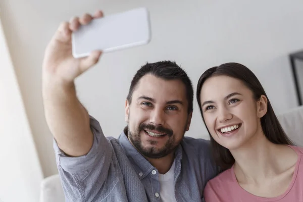 Girl and guy in love making selfie in living room — Stock fotografie