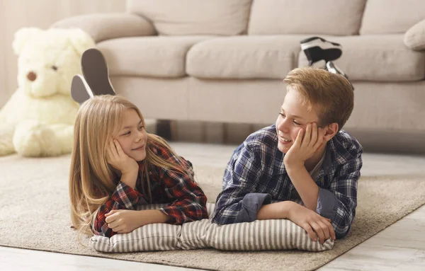 Boy And Girl Lying On Floor Smiling Each Other Indoor — Stockfoto