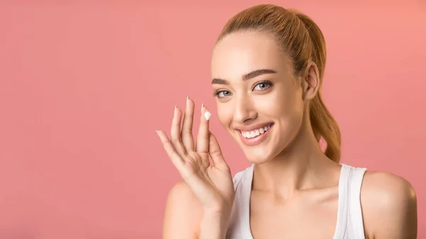 Happy Woman Applying Facial Cream Standing On Pink Background, Panorama — Stockfoto