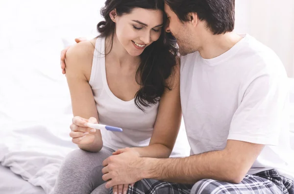 Happy couple with positive pregnancy test, free space — Stockfoto