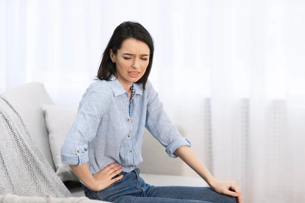 Young woman suffering from pain in side — Stok fotoğraf