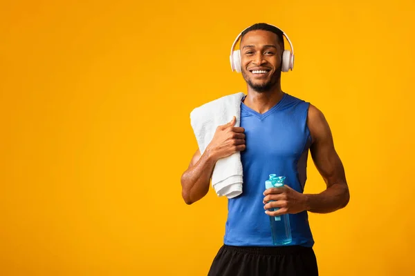 Saudável afro esportes cara segurando garrafa de água mineral — Fotografia de Stock
