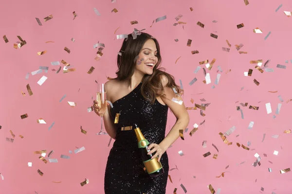 Joyeuse femme en robe de soirée avec bouteille de champagne et verre rempli — Photo