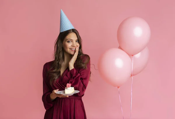 Happy girl holding cake, celebrating birthday with air balloons on background — Stock fotografie