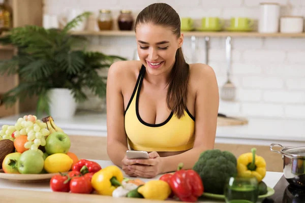 Healthy lifestyle. Woman texting on phone in kitchen — Stockfoto