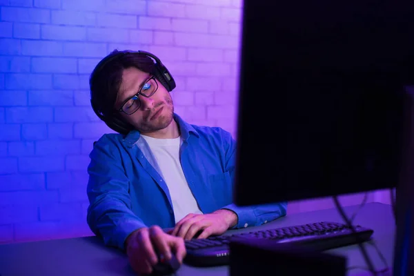 Jugador durmiendo en la PC de escritorio sentado en el escritorio interior, con poca luz —  Fotos de Stock