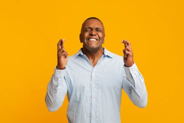 Mature african american man crossing his fingers clipart