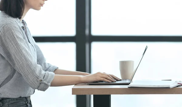 Fata de nerecunoscut care lucrează cu laptop la birou modern — Fotografie, imagine de stoc
