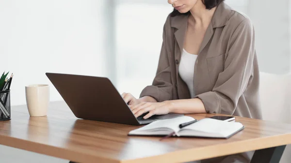 Ung kvinne som bruker bærbar PC på moderne kontor – stockfoto
