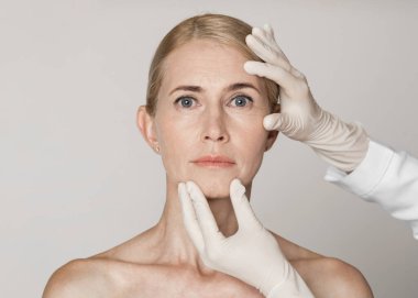 Beautiful mature woman getting treatment at cosmetology clinic