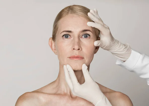 Kaunis kypsä nainen saa hoitoa kosmetiikkaklinikalla — kuvapankkivalokuva