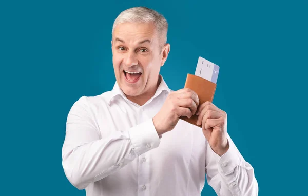 Excited man holding tickets and passport at studio — ストック写真