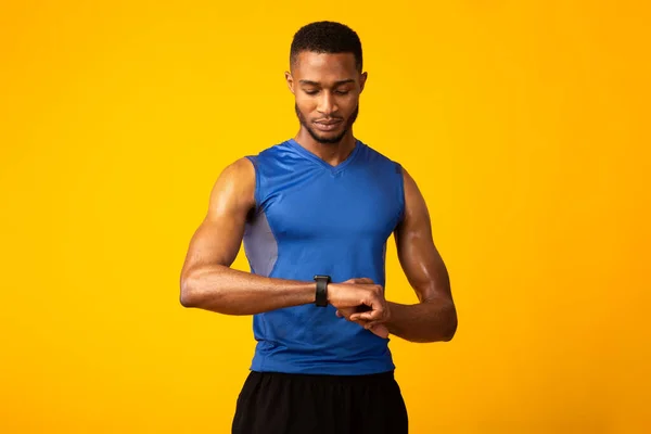 Confident afro guy looking at his smart watch — Stock fotografie