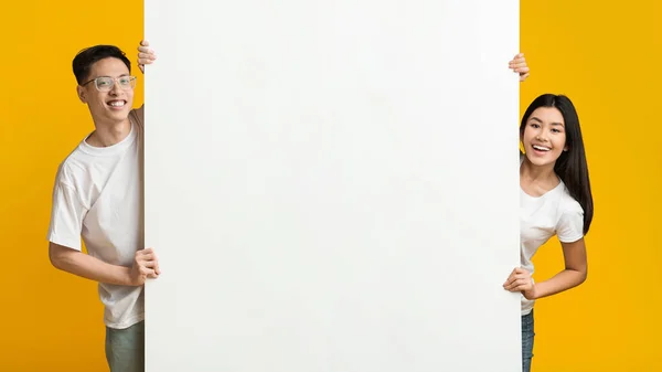 Asian man and woman posing with white empty board — Stok fotoğraf