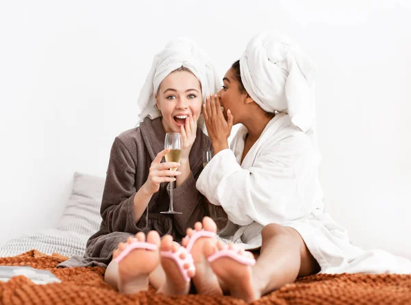 Gorgeous girlfriends sharing secrets, drinking champagne while having pedicure — Stockfoto