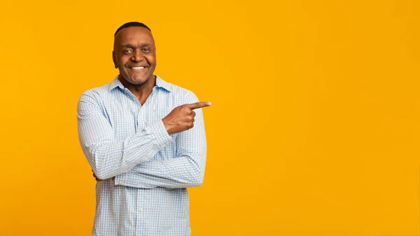 African american mature man pointing aside at empty space — ストック写真