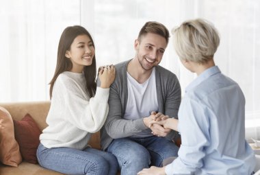 Thankful Couple And Family Counselor Shaking Hands Sitting In Office