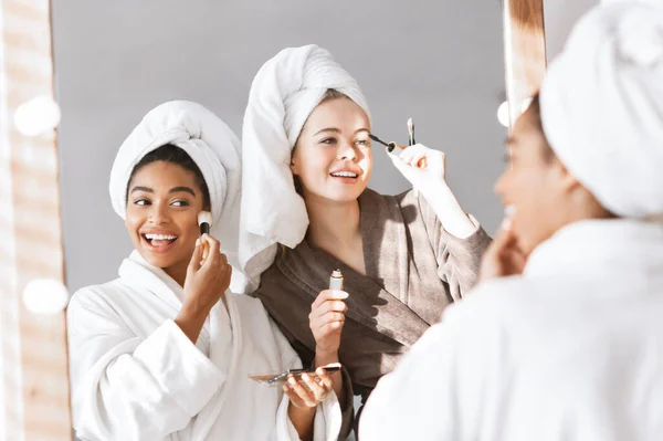 Girlfriends in bathrobes getting ready for party, putting make up — ストック写真