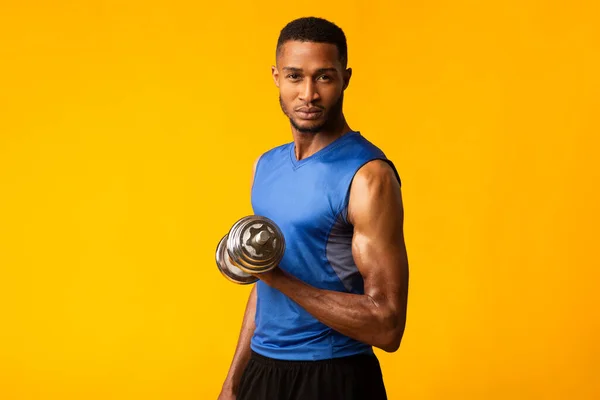 Afro bodybuilder pompt biceps met halters — Stockfoto
